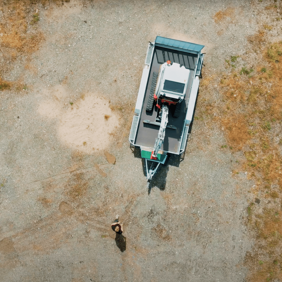 Dronefoto af Robot Trolley der manøvrerer en presenningsdækket trailer